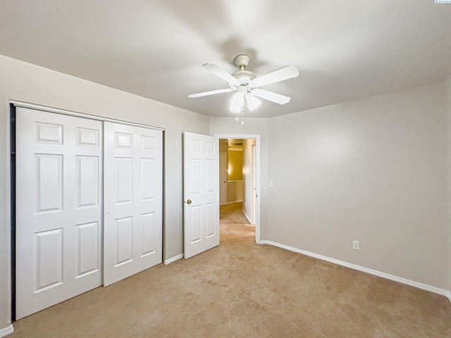 unfurnished bedroom featuring ceiling fan, light colored carpet, and a closet