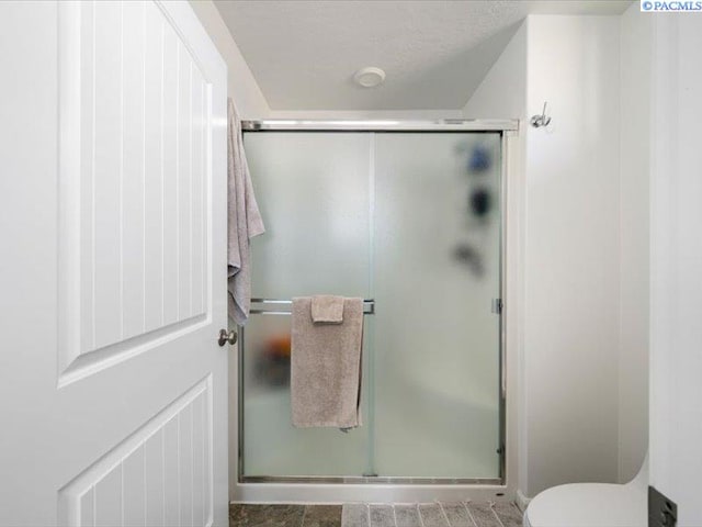 full bathroom with a shower stall and toilet