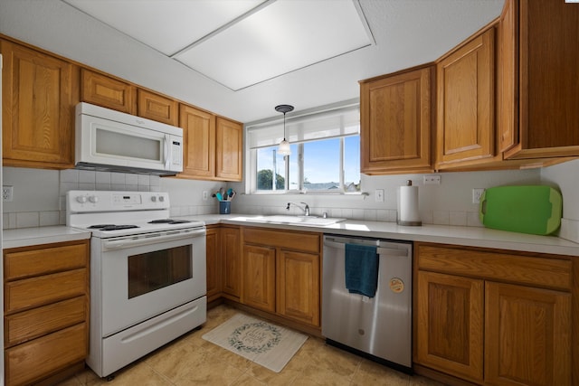 kitchen with light countertops, white appliances, a sink, and brown cabinets