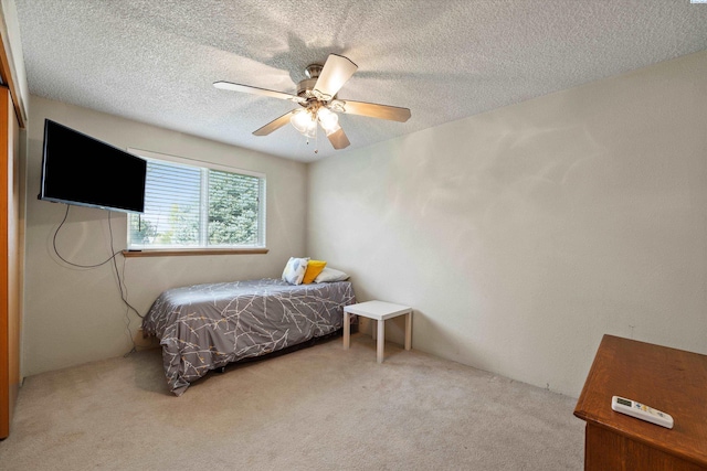 bedroom featuring carpet, a textured ceiling, and a ceiling fan