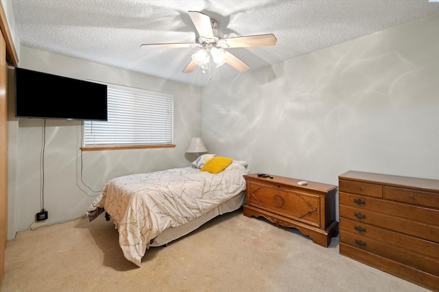 carpeted bedroom with ceiling fan and a textured ceiling