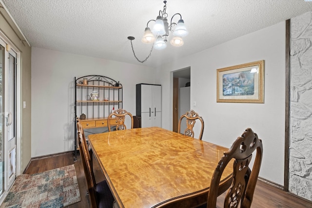 dining space with dark hardwood / wood-style flooring, a notable chandelier, and a textured ceiling