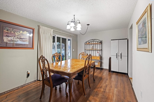 dining area with a notable chandelier, dark wood-type flooring, and a textured ceiling