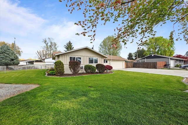 ranch-style house featuring concrete driveway, fence, a garage, board and batten siding, and a front yard