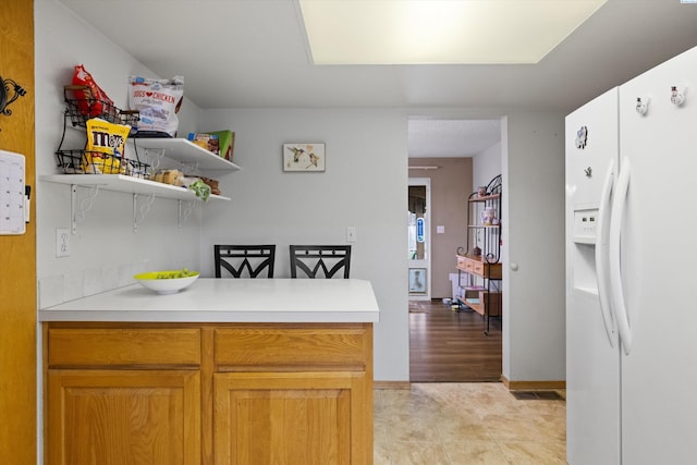 kitchen featuring white refrigerator with ice dispenser