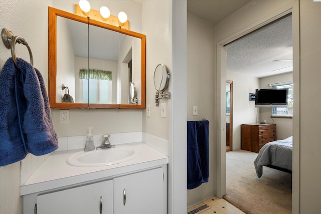 bathroom with vanity, a textured ceiling, and visible vents
