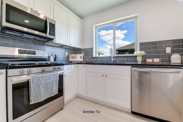 6905 Rd 108, Pasco, WA 99301 - kitchen with appliances with stainless steel finishes, a sink, white cabinetry, dark countertops, and tasteful backsplash
