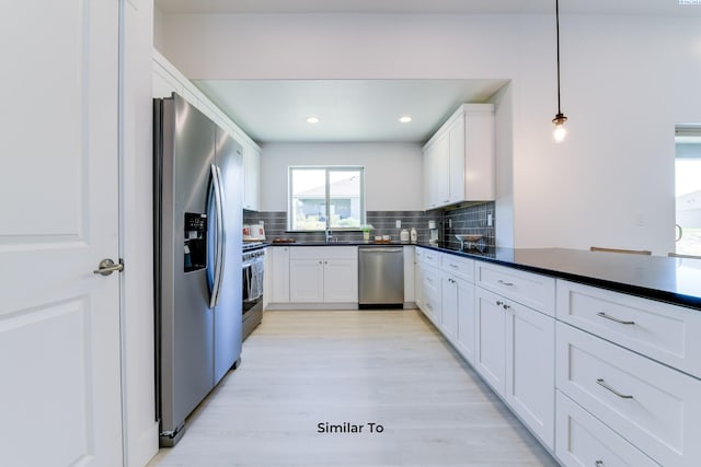 6905 Rd 108, Pasco, WA 99301 - kitchen featuring stainless steel appliances, dark countertops, tasteful backsplash, a sink, and white cabinets