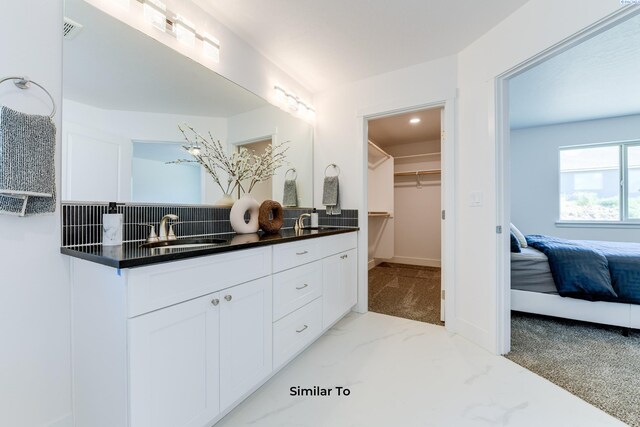 6905 Rd 108, Pasco, WA 99301 - full bath with double vanity, decorative backsplash, ensuite bathroom, marble look tiles, and a spacious closet