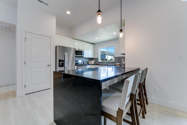6905 Rd 108, Pasco, WA 99301 - kitchen with stainless steel appliances, light wood-type flooring, dark countertops, white cabinetry, and recessed lighting