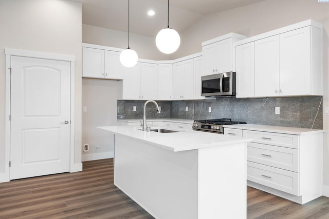 10409 Kokanee Dr, Pasco, WA 99301 - kitchen featuring stainless steel appliances, decorative light fixtures, white cabinets, vaulted ceiling, and decorative backsplash