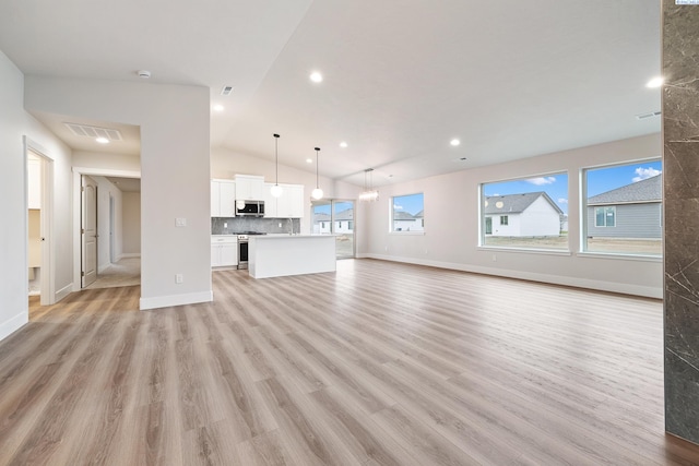 10409 Kokanee Dr, Pasco, WA 99301 - unfurnished living room featuring light wood-style flooring, vaulted ceiling, and recessed lighting