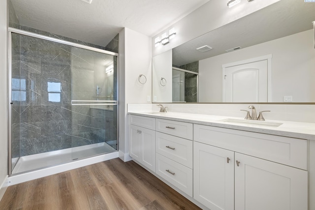 10409 Kokanee Dr, Pasco, WA 99301 - full bath with double vanity, a marble finish shower, and wood finished floors
