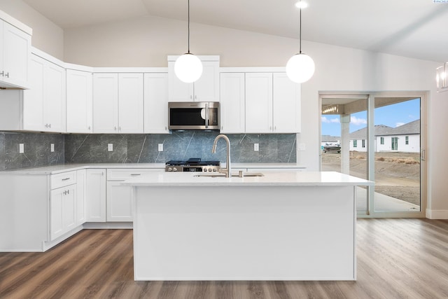 10409 Kokanee Dr, Pasco, WA 99301 - kitchen featuring stainless steel microwave, lofted ceiling, wood finished floors, light countertops, and tasteful backsplash