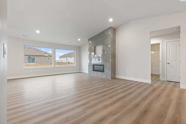 10409 Kokanee Dr, Pasco, WA 99301 - unfurnished living room featuring wood finished floors, lofted ceiling, a tile fireplace, and recessed lighting