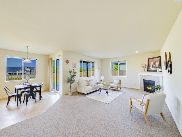 living area featuring light carpet, baseboards, and a fireplace