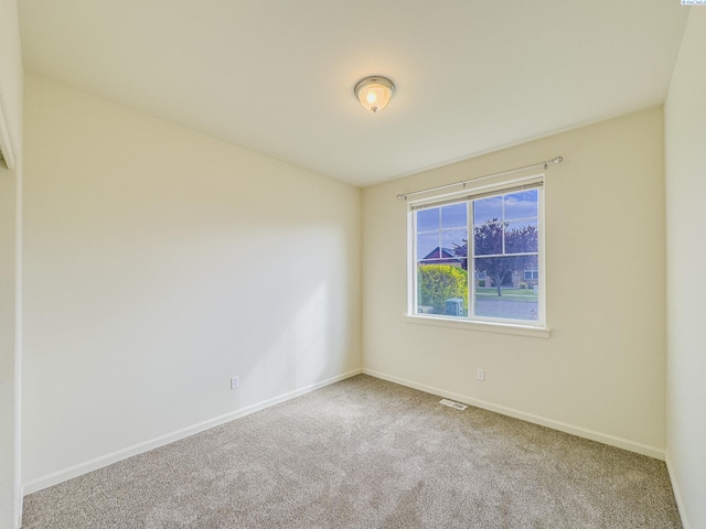 carpeted empty room featuring visible vents and baseboards