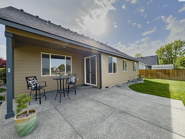 rear view of house featuring a lawn, fence, and a patio