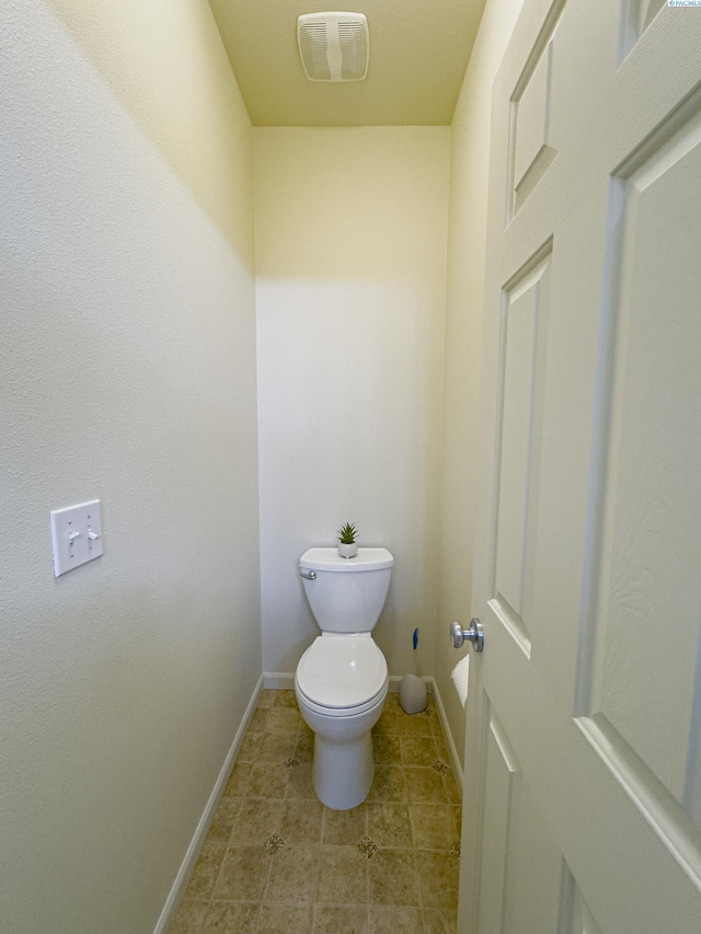 bathroom featuring baseboards, toilet, tile patterned floors, and visible vents