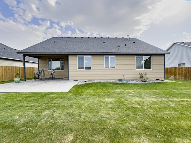 rear view of house with fence, crawl space, a lawn, and a patio