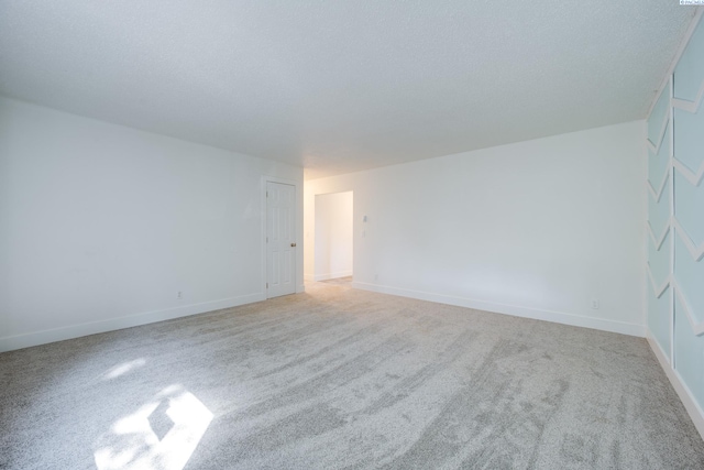 spare room featuring carpet floors and baseboards