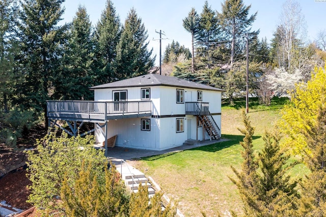 rear view of property with a wooden deck, a yard, and stairway