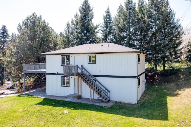 rear view of property featuring a wooden deck, stairs, a patio, and a yard