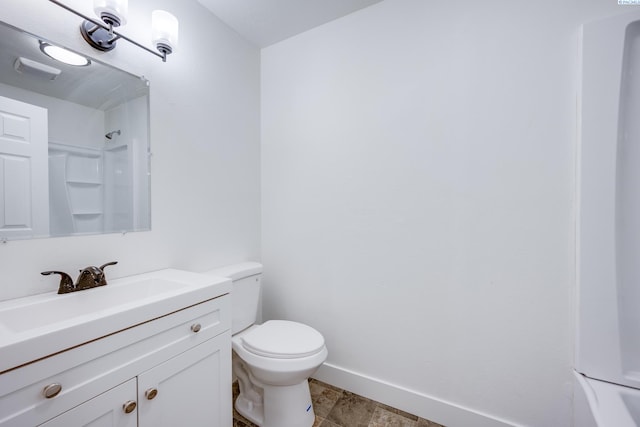 bathroom featuring toilet, baseboards, walk in shower, and vanity
