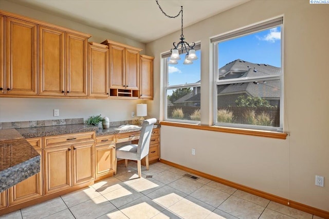 100 S Nevada St, Kennewick, WA 99336 - kitchen featuring built in study area, hanging light fixtures, light tile patterned floors, tile counters, and brown cabinets