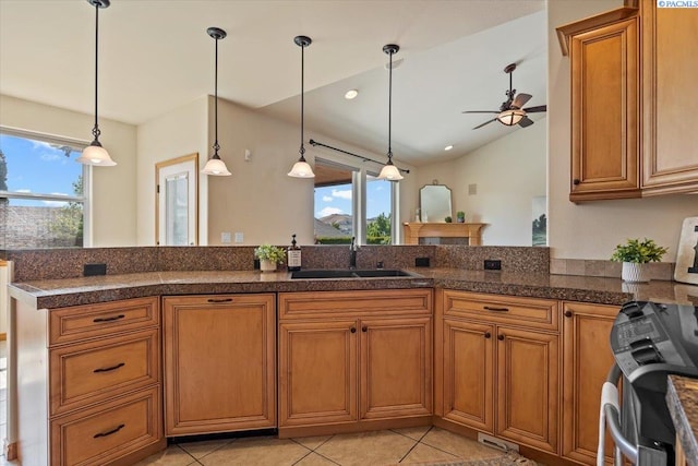 100 S Nevada St, Kennewick, WA 99336 - kitchen featuring ceiling fan, brown cabinets, decorative light fixtures, and vaulted ceiling