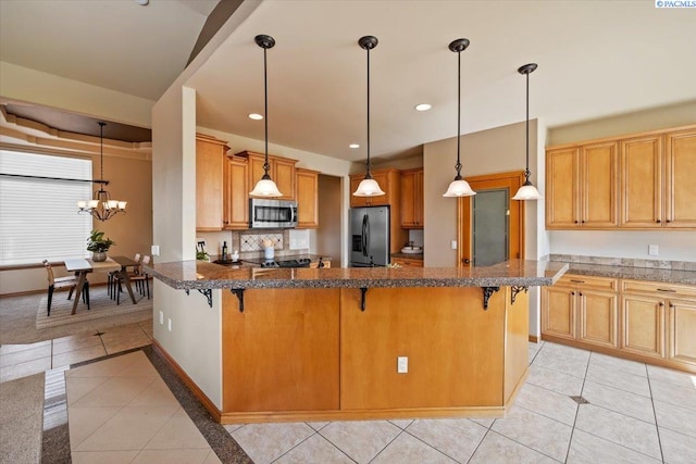 100 S Nevada St, Kennewick, WA 99336 - kitchen with stainless steel appliances, light tile patterned floors, a breakfast bar, and recessed lighting