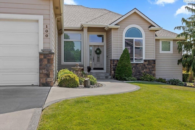 100 S Nevada St, Kennewick, WA 99336 - view of front of property with stone siding, a front yard, a shingled roof, and an attached garage