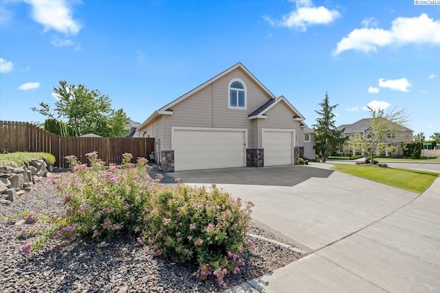 100 S Nevada St, Kennewick, WA 99336 - view of home's exterior with driveway, stone siding, and a garage