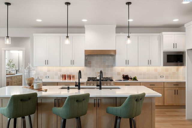 671 Cortona Way, Richland, WA 99352 - kitchen with stainless steel microwave, light wood-style floors, light countertops, backsplash, and custom exhaust hood