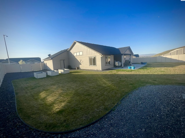230 Ladera St, Prosser, WA 99350 - back of house featuring board and batten siding, a fenced backyard, a yard, and a patio