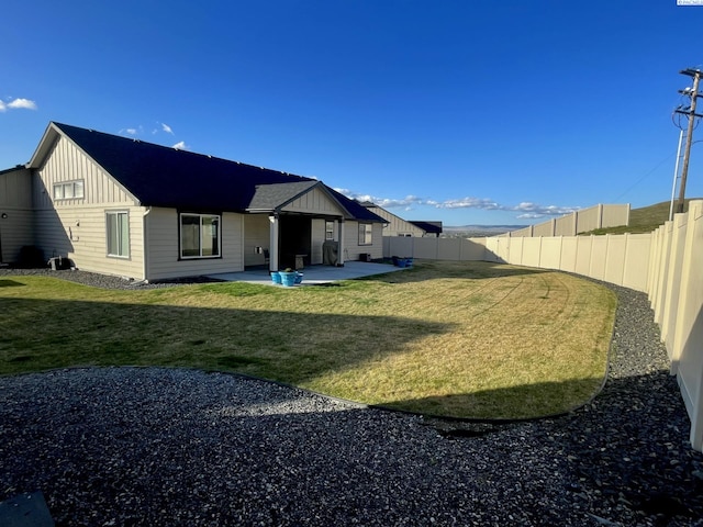 230 Ladera St, Prosser, WA 99350 - back of house with a patio, a fenced backyard, board and batten siding, and a yard
