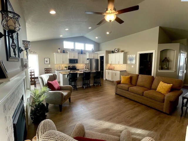 230 Ladera St, Prosser, WA 99350 - living area with vaulted ceiling, recessed lighting, a fireplace, ceiling fan, and wood finished floors