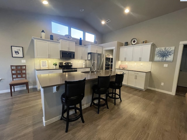 230 Ladera St, Prosser, WA 99350 - kitchen featuring white cabinets, a sink, a kitchen island with sink, stainless steel appliances, and high vaulted ceiling