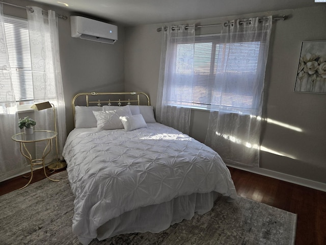 bedroom featuring dark wood-type flooring and a wall unit AC