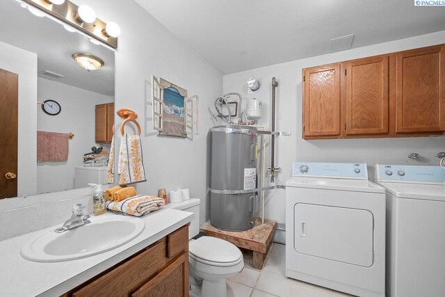 320 SW Kimball Dr, Pullman, WA 99163 - bathroom featuring washing machine and clothes dryer, electric water heater, tile patterned floors, toilet, and vanity