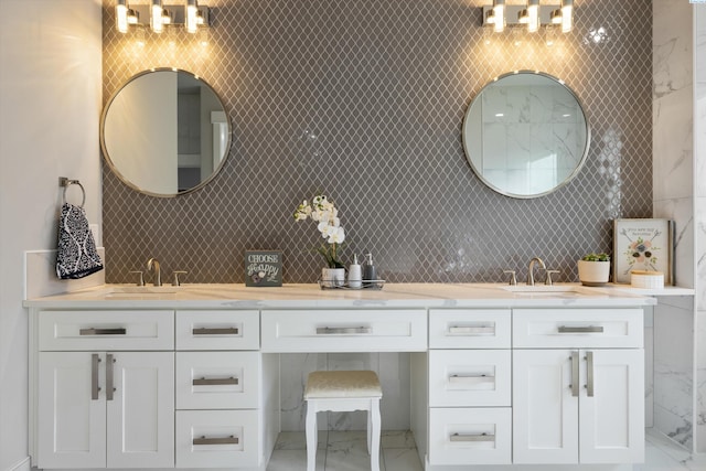 bathroom featuring double vanity, marble finish floor, tasteful backsplash, and a sink