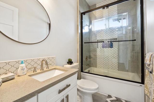 full bathroom featuring enclosed tub / shower combo, vanity, toilet, and decorative backsplash