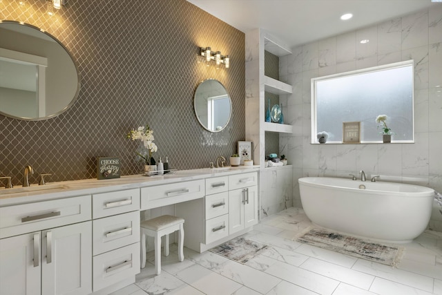 bathroom with recessed lighting, a sink, a freestanding bath, marble finish floor, and double vanity