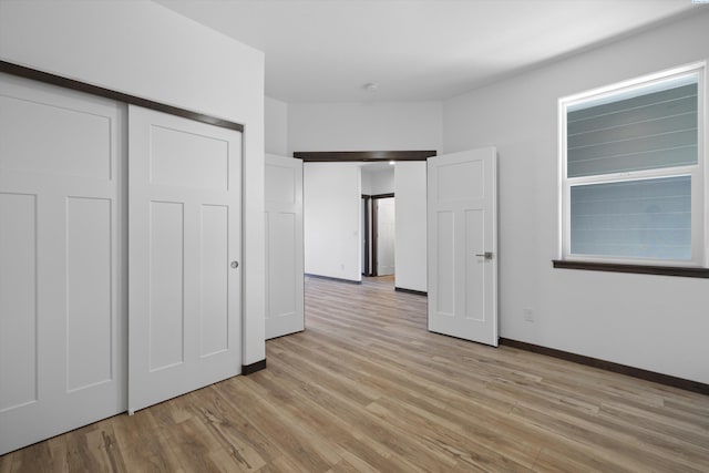 unfurnished bedroom with light hardwood / wood-style floors and a closet