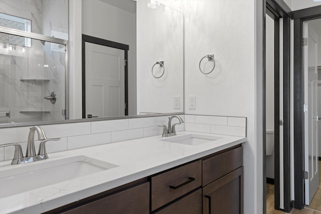 bathroom featuring vanity, decorative backsplash, and walk in shower