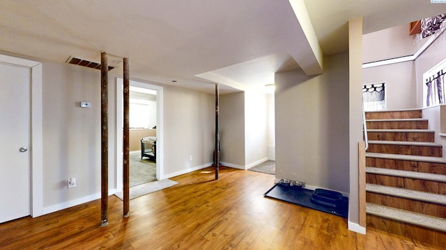 entrance foyer featuring wood finished floors, visible vents, baseboards, and stairs