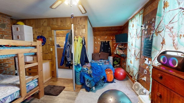 bedroom featuring wooden walls and wood finished floors