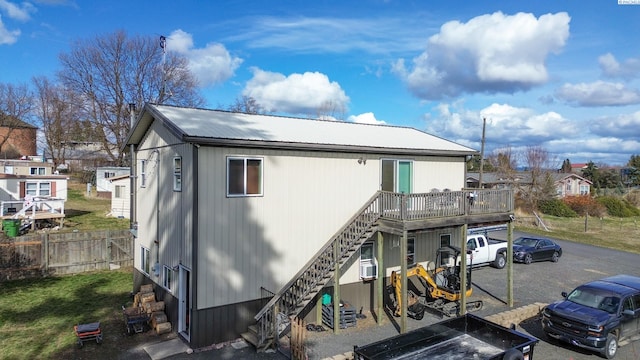 exterior space featuring a deck, stairs, fence, and metal roof