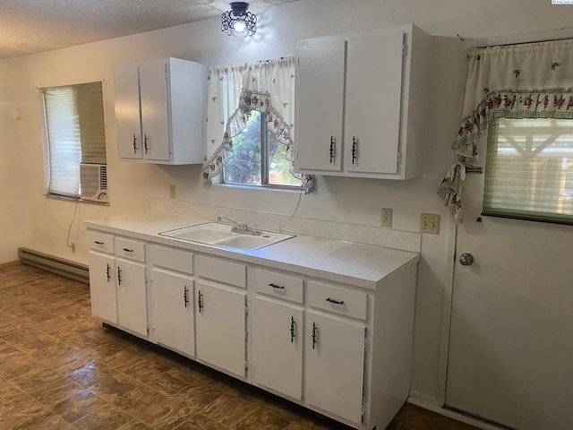 1026 Hemlock St, Prosser, WA 99350 - kitchen with a baseboard radiator, light countertops, white cabinets, and a textured ceiling