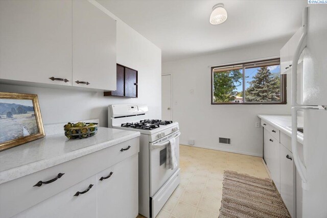 1923 Hood Ave, Richland, WA 99354 - kitchen with white appliances, light countertops, light floors, and white cabinets